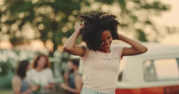 特写非洲女孩与卷曲的头发跳在前面的相机在野餐有一个美丽的笑容, 和快乐的脸. — 图库视频影像