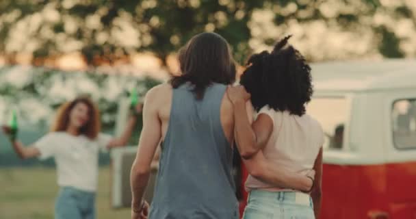 Twee koppels hebben een geweldige tijd op de picknick die ze een retro busje naast hebben. Slow-motions — Stockvideo