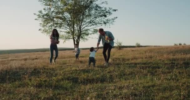 Twee kleine broertjes en hun deel bij natuur verbazingwekkend zonsondergang, maken bubbels. — Stockvideo