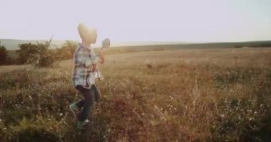 Yakışıklı, alan, şaşırtıcı güneş ışığı ile büyük bir lolipop ile çalışan küçük çocuk.