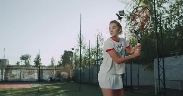 Jong meisje met tennis op de tennisbaan, goede zonnige dag, professionele speler. — Stockvideo