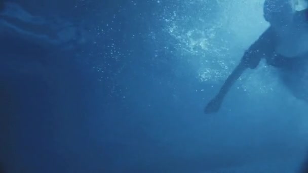 Femme incroyable dans une robe noire nageant dans la nuit sur la piscine un clair de lune tombe dans l'eau .