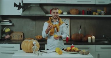 Cadılar Bayramı ruh mutfak, kamera, mini portakal ile şık adam, iyi bir ruh hali hokkabazlık bir adam.