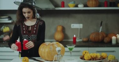Onun mutfak için bir Halloween, o mum alarak ve kabak koyarak için dekore edilmiş karizmatik Asya Bayan.