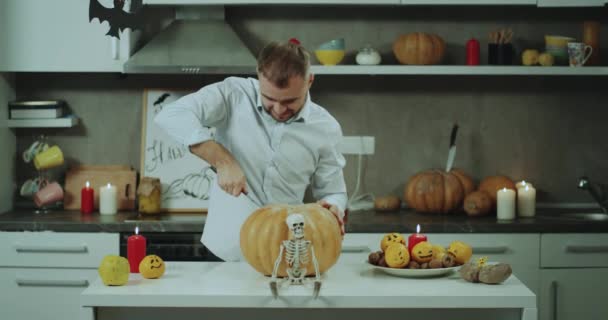Man Trying Cut Big Pumpkin His Kitchen Table Halloween Party — Stock Video