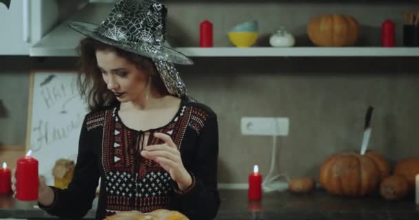 Pani maskowane w czarownica urządzone jej kuchnia dla Halloween party. — Wideo stockowe