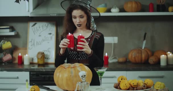 Bella strega mascherata che gioca con le candele davanti alla fotocamera si preparano per la festa di Halloween. 4k — Video Stock