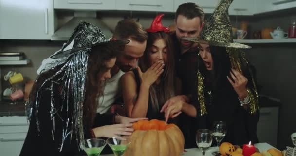 Skupina přátel stojan až nad velké dýně a učinit některé kouzelnické triky, Halloween atmosféra, krásné multikulturní lidí. Střílel na Red Epic. pomalé pohyby. — Stock video