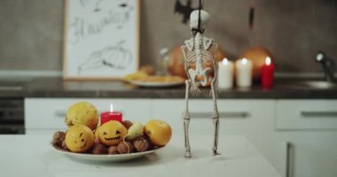 Mutfak, mumlar, pumpkins, çok komik dacing bir iskelet mutfak masasının üzerinde Halloween süslemeleri.