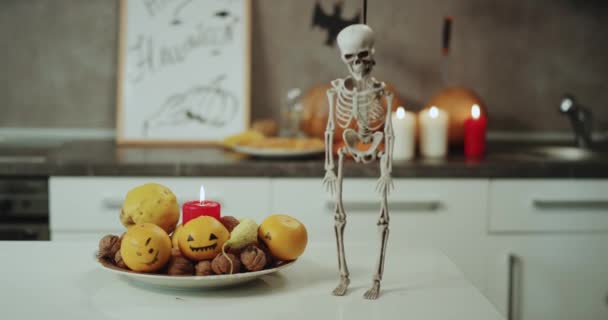 Dacing funny skeleton on kitchen table on Halloween night, background Halloween decorations. Stock Video