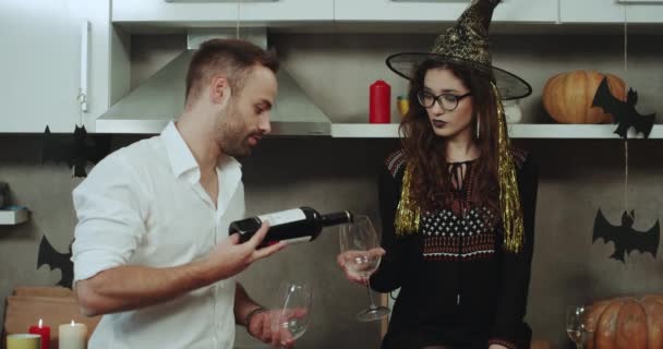 Beau jeune couple multiculturel passer un moment romantique la nuit d'Halloween, boire du vin rouge et passer du bon temps ensemble dans la cuisine avec Halloween incroyable . — Video