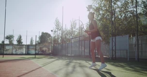 Παιχνίδι τένις στο ηλιόλουστη μέρα, η γυναίκα που κινείται πολύ επαγγελματική ρακέτα στο γήπεδο του τένις. — Αρχείο Βίντεο
