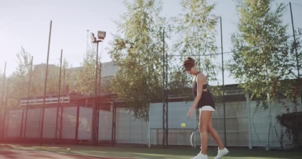 Mujer Sportiv jugando tenis profesional en la pista de tenis, día soleado fuera. — Vídeos de Stock