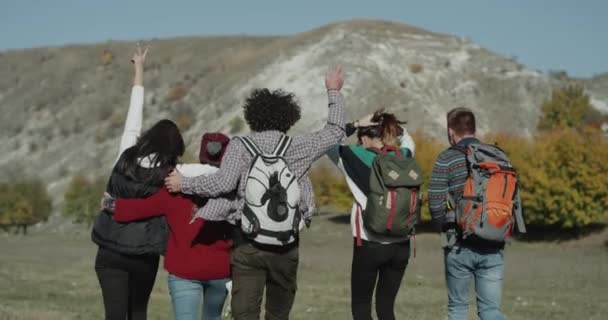 Trois jeunes femmes et deux gars passent un bon moment ensemble pour le voyage, avec un grand sac d'exposition, capturant de l'arrière. 4k — Video