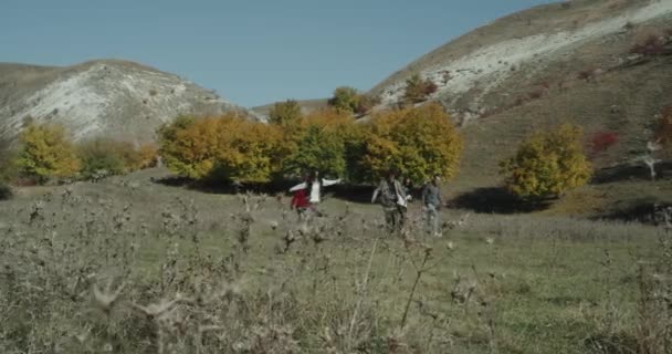 No meio da montanha andando grupo de pessoas multiculturais com grandes sacos de viagem, clima feliz ambiente bonito . — Vídeo de Stock