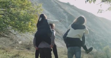 İki çift var eğlenceli bir dağ ortasında vakit, kızlar üzerinden atlama arka ve mutlu birlikte mükemmel bir vakit erkek arkadaşları.