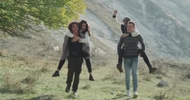 İki adam sırt onların kız onlar-si olmak bir mutlu anları dağın ortasında taşıdı. 4k