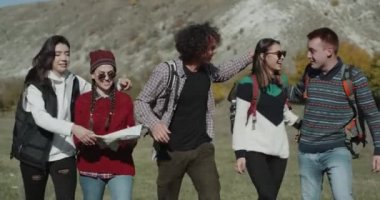 Arka tarafta büyük bir çanta ile dağ yoluyla büyük bir gezi olacak mutlu arkadaş mutlu gülümseyen büyük şirket var harika bir ruh hali, sarılma ve birbirleriyle konuşmak.