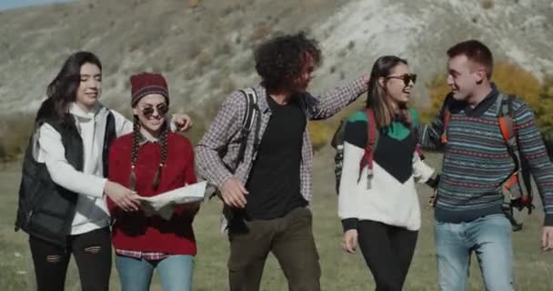 Boldog mosolygó nagy cég a barátok lesz boldog egy nagy utazás keresztül a hegy, a hátsó, nagy táskákkal van egy nagy hangulat, átölelve és beszél egymással. — Stock videók
