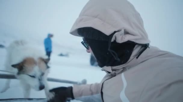 Winterzeit in den Bergen, Mann spielt mit Hund und filmt sich selbst. — Stockvideo