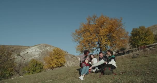 Ausstellungszeit für eine große Gruppe von Freunden Multi-Race, sie haben Pause in der Mitte der erstaunlichen Landschaft Blick durch die große Karte und versuchen, das nächste Ziel zu finden. — Stockvideo