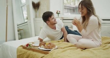Komik Fransız kruvasan yemek ve iyi bir zaman birlikte kendi rahat yatak odasında harcama yatakta kahvaltı çift var.