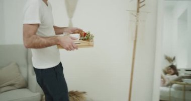 Yatakta harika sabah kahvaltı, veren adam biraz kırmızı alarak romantik bir çift için onun Bayan gül, mutlu çiçek kokuyor.