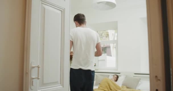 Colazione del mattino, l'uomo porta la colazione nel letto per la sua donna, camera da letto in stile accogliente . — Video Stock