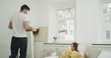 Genç adam getirmek onun kız arkadaşı için kötü odaya, rahat yatak odasında mükemmel sabah.