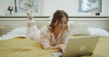 Pembe bir şık pijama giyiyor yatağında bırakmasını defterini dokunarak karizmatik genç kadın.