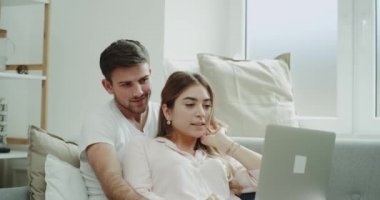 Genç çift defter bir şey kırmızı epik sofa.shot oturan sabah sipariş