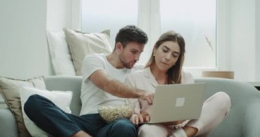 Patlamış mısır yemek ve defter rahat bir oturma odasında film izlerken kadın ve genç adam. Kırmızı epic vurdu