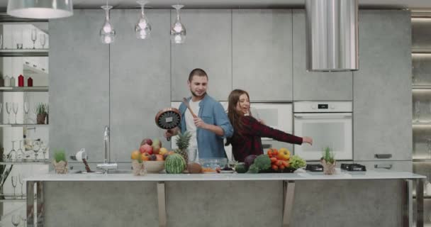 Closeup dacing casal na cozinha antes de preparar o café da manhã na parte da manhã, muito carismático boa aparência . — Vídeo de Stock