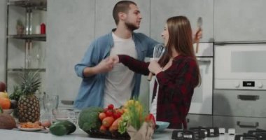 Bir modern mutfak genç adam ile onun kız arkadaşı dacing romantik yemek yaparken, onlar çok karizmatik.