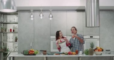 Modern bir pisi, sağlıklı bir kahvaltı güler yüzlü ve dacing aynı anda içme sonra çift Olgun.
