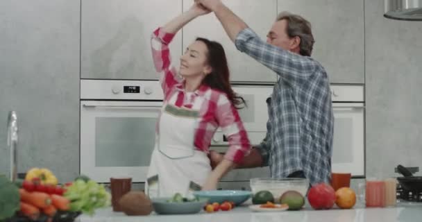 Muy hermosa pareja madura en la cocina pasar un momento romántico mientras que la fabricación de dacing comida y tener un buen estado de ánimo. 4k — Vídeos de Stock