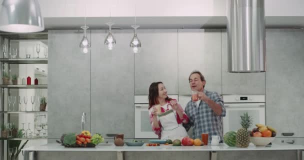 In einem modernen Kätzchen reifes Paar nach einem gesunden Frühstück Smoothie trinken und gleichzeitig tanzen. — Stockvideo