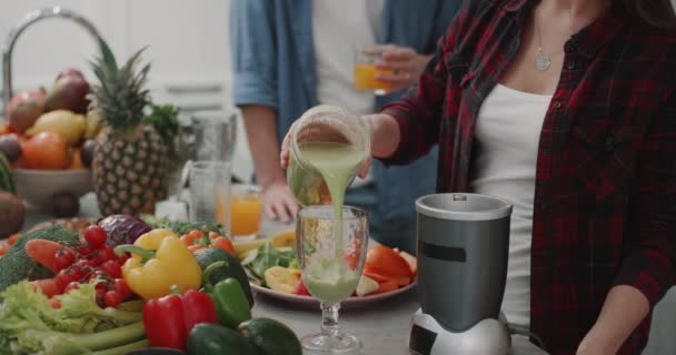 Closeup smoothie time in the morning for a healthy breakfast , couple prep together , a green smoothie. — Stock Video