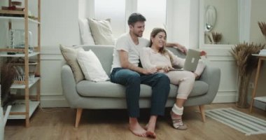 Birlikte pijama onların oturma odasında genç bir çift harcama, kanepede oturan ve laptop bir şey izlerken mutlu saat,