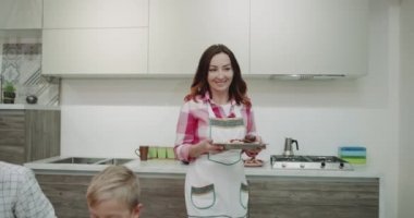 Çekici Olgun kadın onlar yemek masasında yemek geliyor iken onun dizüstü bilgisayarda çalışan adam bekliyor onu aile üyeleri için sabah yemek getiriyor. 4k