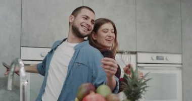 Neşeli çift pişirmeye başlamadan önce modern mutfakta kahvaltı onlar şarkı ve birlikte komik dans.