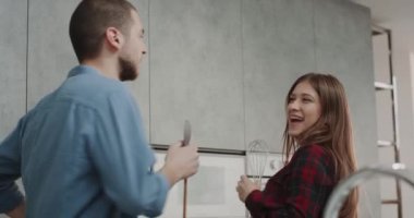 Pişirme süresi genç karizmatik bir çift ile mutfakta hangi dacing ve aynı zamanda modern bir gri mutfak şarkı.