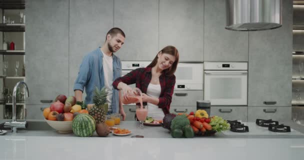 In een moderne keuken met een paar mooie design in de ochtend met behulp van een blender samen een gezonde smoothie te maken, het vastleggen van alle van het proces. — Stockvideo