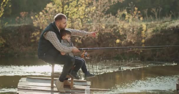 Krásný podzimní den táta se synem strávit krásné chvíle spolu chytit nějaké ryby z jezera. — Stock video
