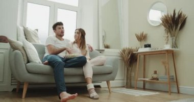 Hafta sonu mutlu çift harcama birlikte kanepede oturan ve tv şaşırtıcı rustik tasarım izlerken patlamış mısır yemek.