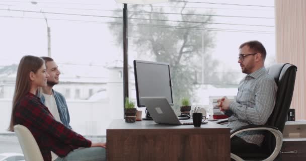 Genç çekici çift bir banka müdürünün, onun ofisinde, tablo muhteşem panoramik görünüm üstünde laptop görüşme. — Stok video