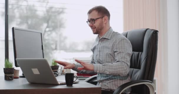 彼は彼のオフィスの椅子に座っての手でサインを送るビジネス プランに関するすべての詳細がパノラマ ビューを説明彼のパートナーと会議がある実業家 — ストック動画