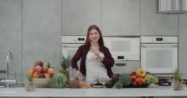 Dacing karizmatik kadın çok modern mutfak bir el mikseri ile şarkı mutfakta yemek yaparken. 4k