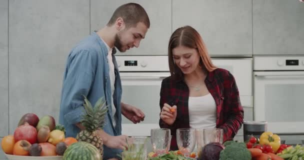 Mooie paar in de ochtend hebben een goed humeur gelukkig dranken verse jus d'orange vóór het koken van het ontbijt. — Stockvideo
