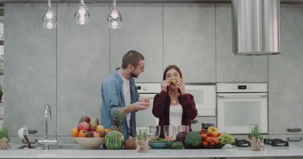 Vicces időt a konyhában egy vegán pár játék zöldségekkel, bajusz, így a reggeli főzés megkezdése előtt. — Stock videók